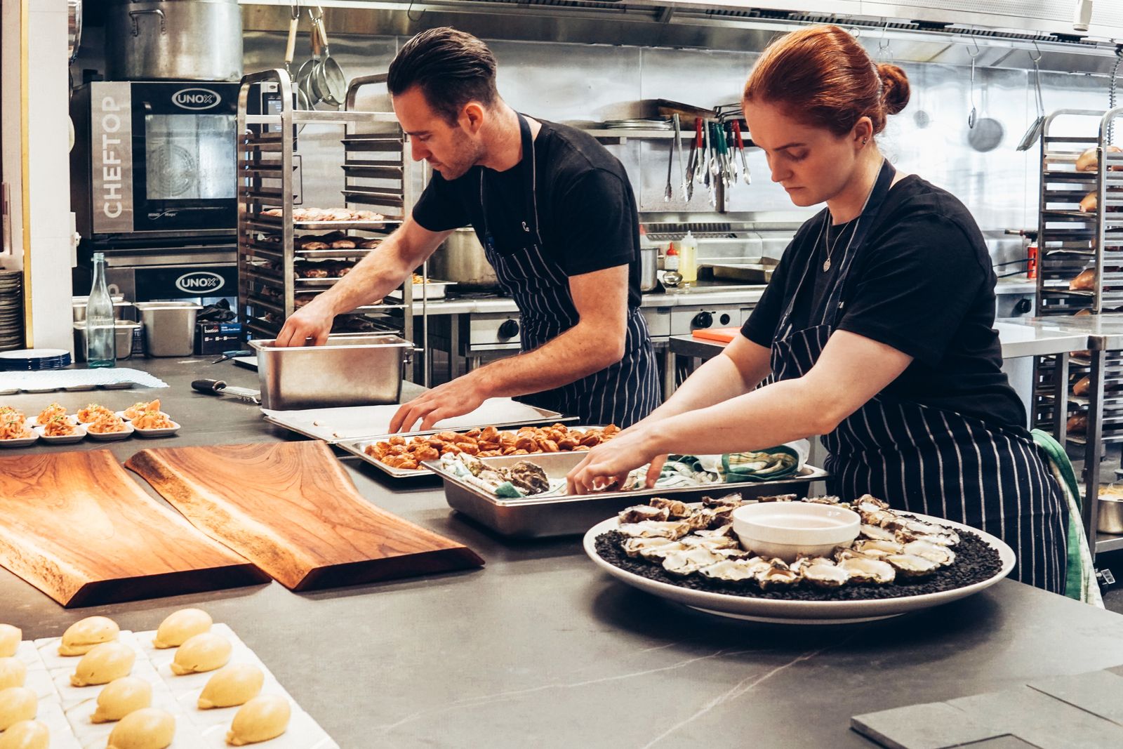 Commercial kitchen team washing and stacking tableware during service